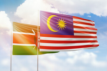 Sunny blue sky and flags of malaysia and kenya