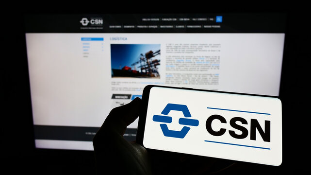 Stuttgart, Germany - 06-12-2022: Person holding cellphone with logo of company Companhia Siderurgica Nacional (CSN) on screen in front of business webpage. Focus on phone display.