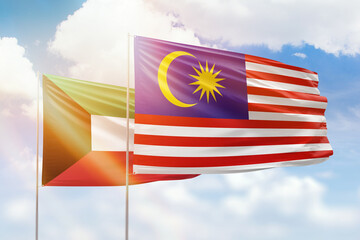 Sunny blue sky and flags of malaysia and kuwait