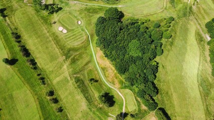 Aerial view looking down onto a golf course with green trees and bunkers.  © ReayWorld