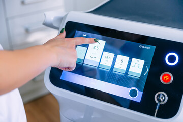 female hand adjusts the device on the touch screen before the procedure.