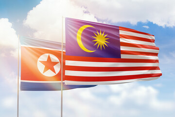 Sunny blue sky and flags of malaysia and north korea