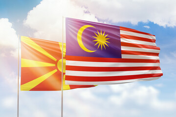 Sunny blue sky and flags of malaysia and north macedonia