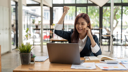 Portrait of happy young business asian woman celebrating success with arms up. positive expression, success in business concept