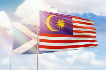 Sunny blue sky and flags of malaysia and scotland