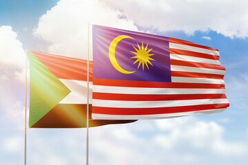 Sunny blue sky and flags of malaysia and sudan