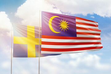 Sunny blue sky and flags of malaysia and sweden