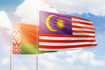 Sunny blue sky and flags of malaysia and belarus