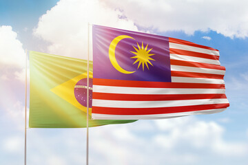 Sunny blue sky and flags of malaysia and brazil