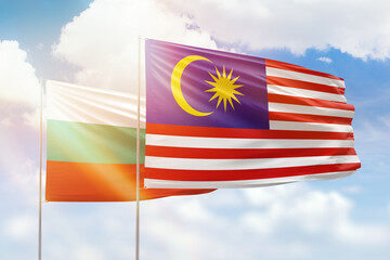 Sunny blue sky and flags of malaysia and bulgaria