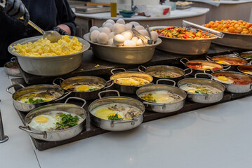 Typical Israeli breakfast buffet at any hotel. Egg buffet with hard boiled, scrambled, shakshuka and egg with white sauce and mushrooms plus potatoes and vegetables.
