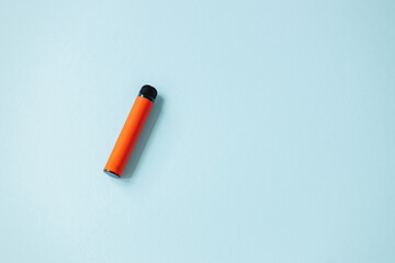 One disposable orange e-cigarettes. Concept of bad habits, modern smoking electronic cigarettes.