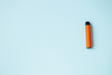 One disposable orange e-cigarettes. Concept of bad habits, modern smoking electronic cigarettes.