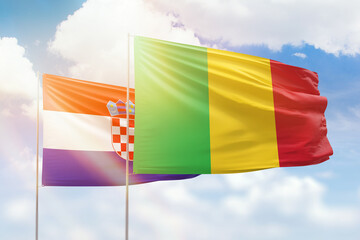 Sunny blue sky and flags of mali and croatia