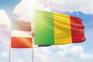 Sunny blue sky and flags of mali and dominican republic