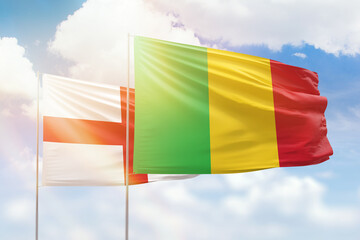 Sunny blue sky and flags of mali and england