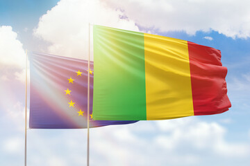 Sunny blue sky and flags of mali and european union