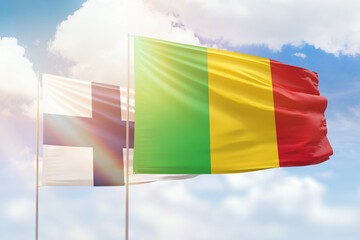 Sunny blue sky and flags of mali and finland