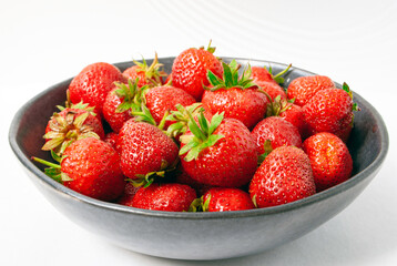 Strawberries in a bowl on a white background