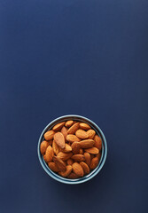 Almond bowl on a blue background viewed from above. Top view. Copy space