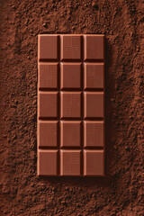 Chocolate bar on a cocoa background viewed from above. Top view