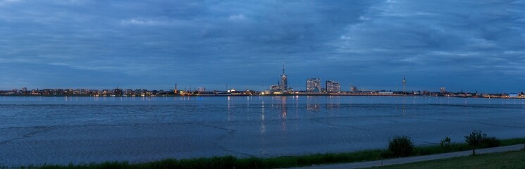 evening panorama of the Bremerhaven skyline seen from the opposite shore of the river Weser - translation: "Willy-Brandt-Platz" is the name of the square, no logo