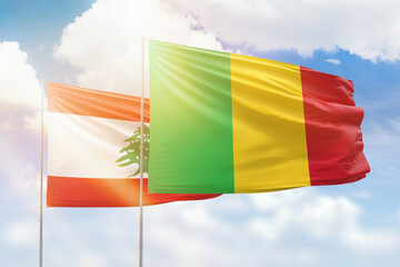 Sunny blue sky and flags of mali and lebanon
