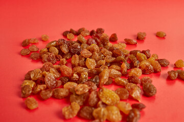 Many raisins scattered on a red background.