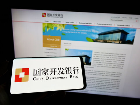 Stuttgart, Germany - 06-12-2022: Person holding smartphone with logo of China Development Bank (CDB) on screen in front of website. Focus on phone display.