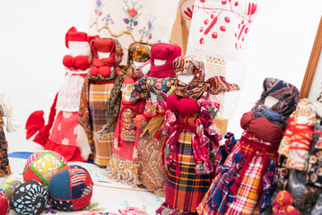 Russian folk toys made of wood. Nesting dolls of different types. Straw dolls with sundresses. Utensils for playing. Festival of Nationalities and Religions.