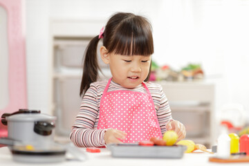 young  girl pretend play food preparing at home