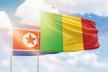 Sunny blue sky and flags of mali and north korea