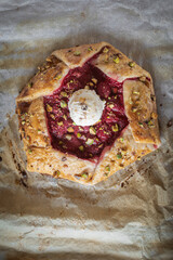 Rustic homemade cake with raspberries, pistachios and puff pastry. Homemade raspberry galette.