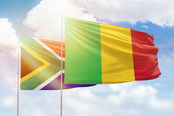 Sunny blue sky and flags of mali and south africa