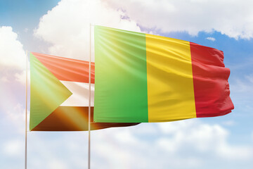 Sunny blue sky and flags of mali and sudan