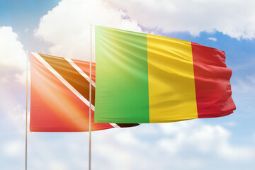Sunny blue sky and flags of mali and trinidad and tobago