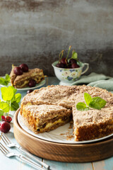 Homemade summer pastry gluten free. Chocolate and cottage cheese pie with cherries on a rustic table. Copy space.