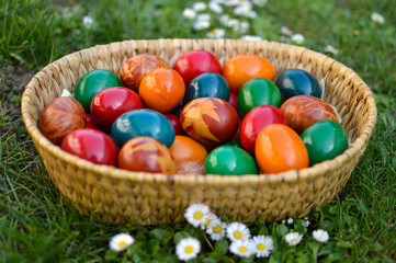 colored Easter eggs in the basket lying in the grass