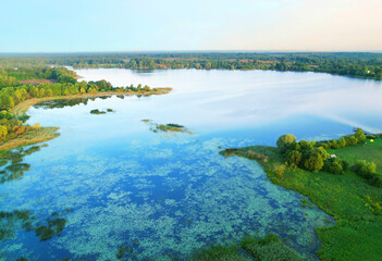Lake in wild nature, aerial view. Lake on sunset in summer. Aerial panoramic landscape view of lake...