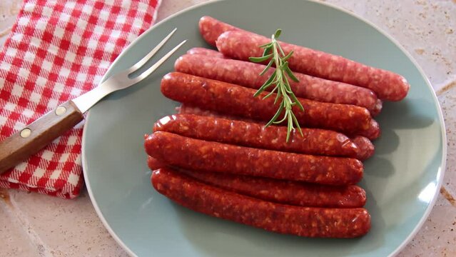 assiette de merguez et saucisses crues pos&eacute; sur une table