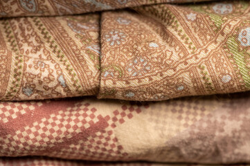 Pieces of fabric with different patterns, stacked. Close-up, selective focus