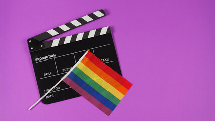 A rainbow flag and black clapperboard on purple background. LGBT CONCEPT..