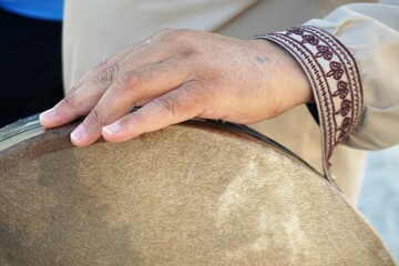 Hand von arabischem Musiker an Trommel 