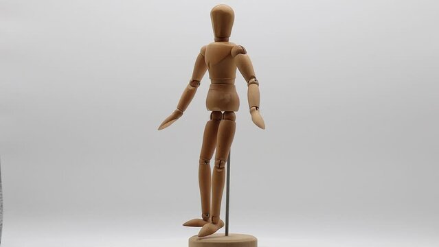Wood mannequin over white background rotating.