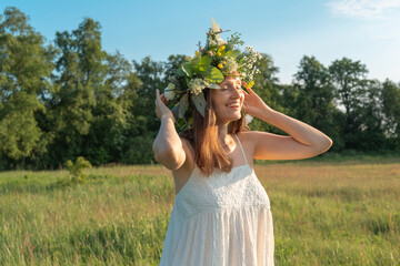 Beautiful brunette woman in flower wreath. Summer solstice day. Midsummer.