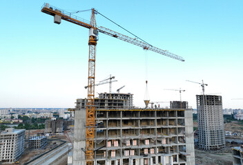Сonstruction site with tower cranes on building construction. Builder on formworks. Cranes on pouring concrete in formwork. Tower cranes on construction in built environment. Buildings renovation..