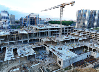 Сonstruction site with tower cranes on building construction. Builder on formworks. Cranes on pouring concrete in formwork. Tower cranes on construction in built environment. Buildings renovation..