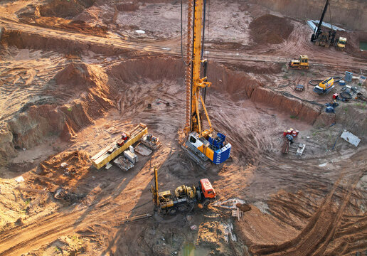 Deep foundation machine. Drilling rig and Pile driver at construction site. Pile driven into ground by vibrating hydraulic hammer. Foundations construction work. Ground drilling and Piling Contractor.