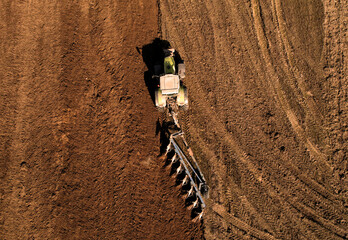 Tractor plowing field. Tractor plow soil cultivating. Cultivated land and soil tillage....