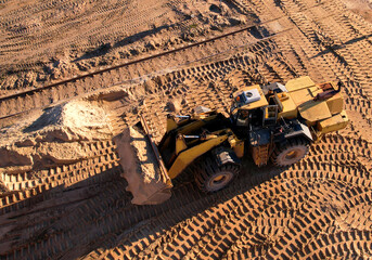 Front-end loader during digging and excavation operations in open pit. Wheel loader load the sand...